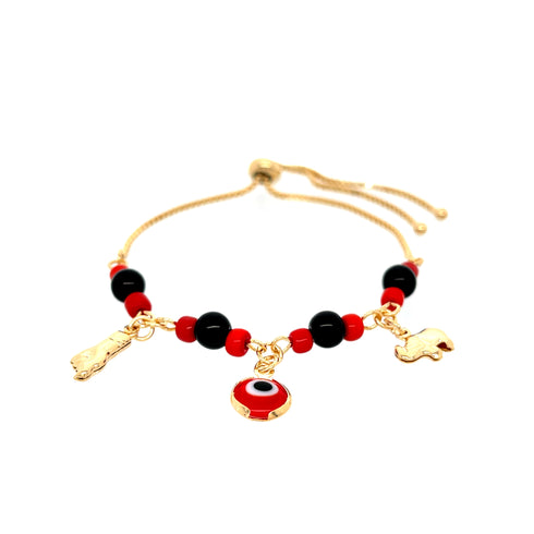 The Red and Black Evil Eye, Figa hand and Elephant lucky charm bracelet features a 14k gold-filled chain adorned with vibrant red and black beads. This elegant accessory includes three distinct charms: a dangling red and black circular charm, a gold figure charm, and a gold elephant. The adjustable chain ends provide the perfect fit for this fashionable bracelet.